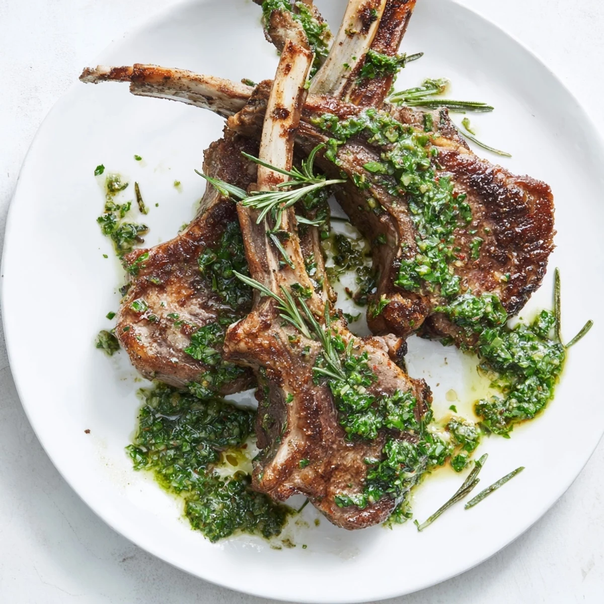Close-up of succulent Rustic Mint Weeknight Pan-Seared Lamb Chops, beautifully tender with perfect sear marks, beside refreshing mint.