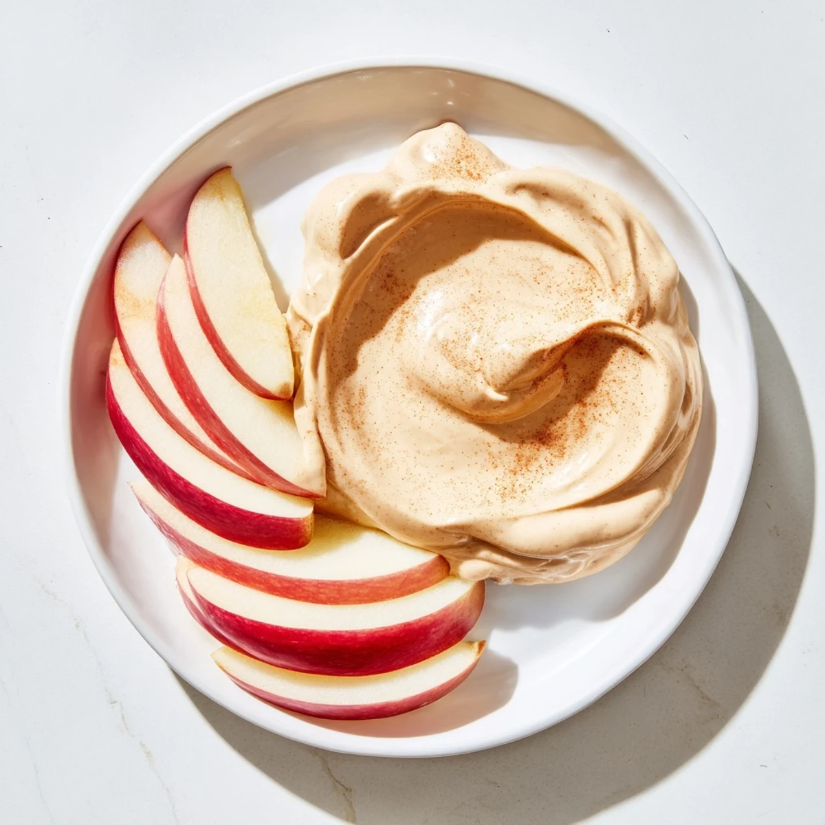 Fresh, juicy apple slices alongside a creamy peanut butter dip, a perfect snack.