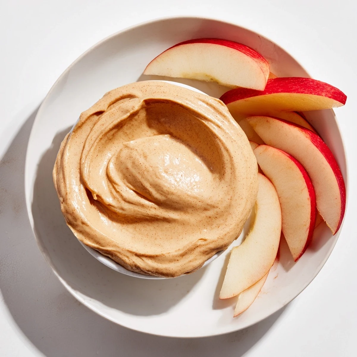 Dipping crisp apple slices into a smooth and delicious peanut butter dip for a quick American snack.