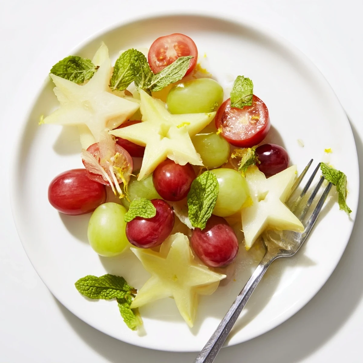 Vibrant brunch fruit pairing: sliced starfruit and grapes, artfully arranged for garnish, ready to eat.