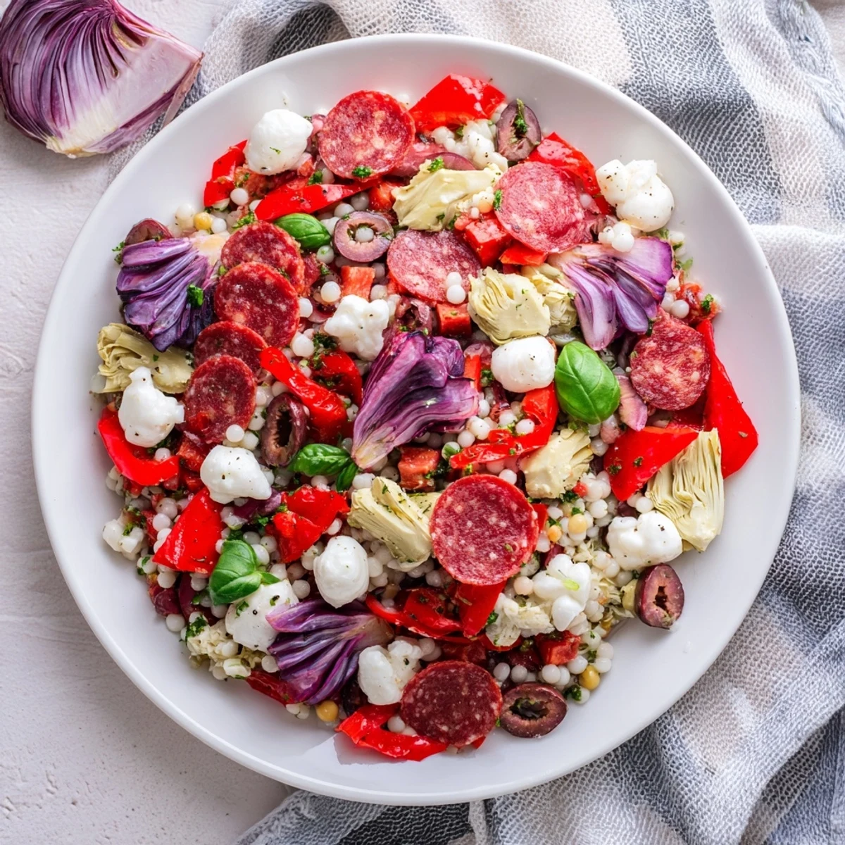 A close-up of Antipasto Chickpea Salad, showcasing mozzarella pearls, pepperoni, and colorful vegetables for a delightful meal.
