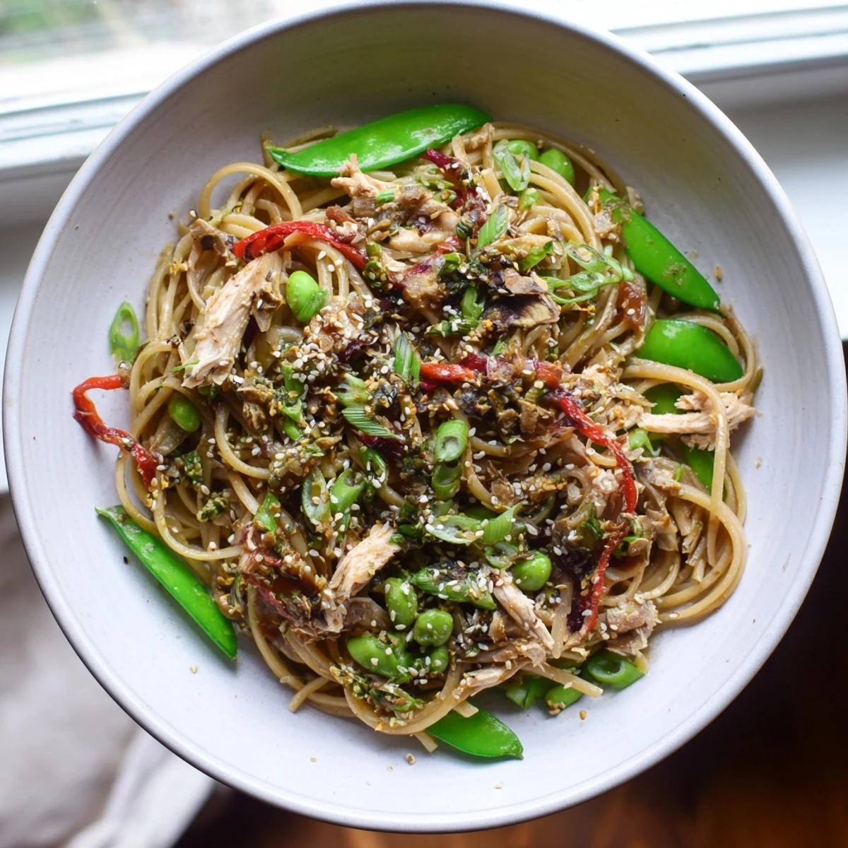 Steaming-hot sesame hoisin ground chicken pasta, a vibrant dish with glistening noodles and tender chicken.