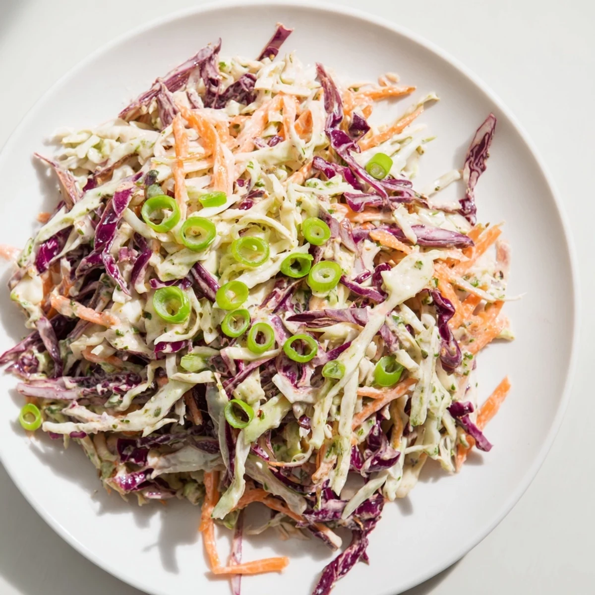 This quick coleslaw salad, with a creamy white dressing, offers a refreshing side dish for sandwiches.