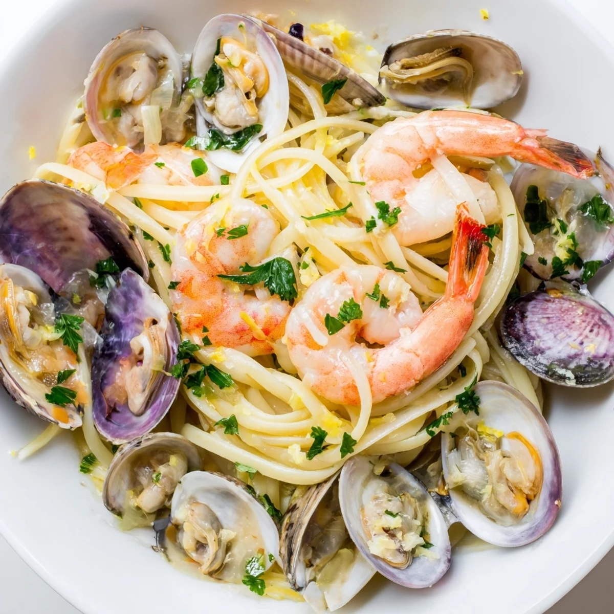 Bright lemon wedges and parsley top this Seafood Linguine, highlighting the tender shrimp and open shells on al dente pasta.
