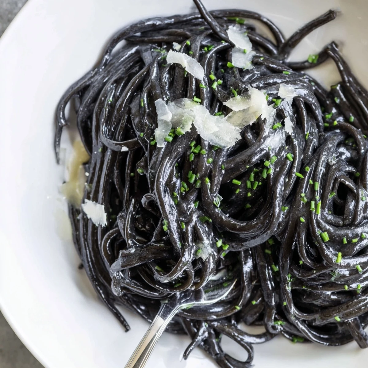 Steamed mussels and clams rest atop silky squid ink pasta in a garlicky white wine sauce.