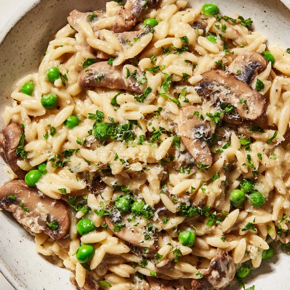 Golden Orzo Mushroom Risotto-Style pasta in a white bowl, topped with fresh parsley and extra Parmesan.