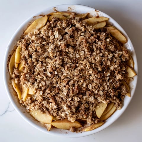 Golden-brown spiced apple crisp with a buttery, soft crumb topping, perfect for dessert.