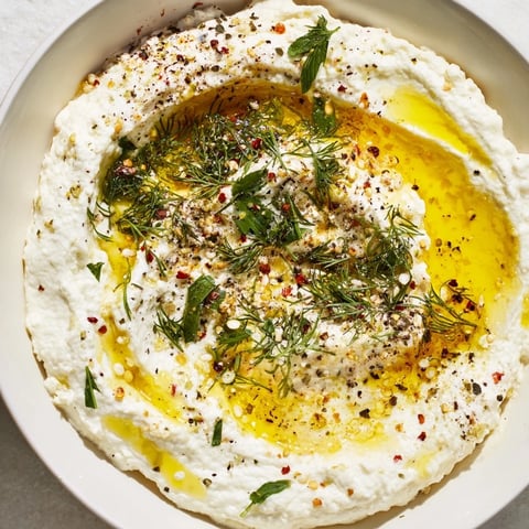 Creamy Angel Wings Whipped Feta Dip beautifully swirled, drizzled with golden honey and fresh herbs.