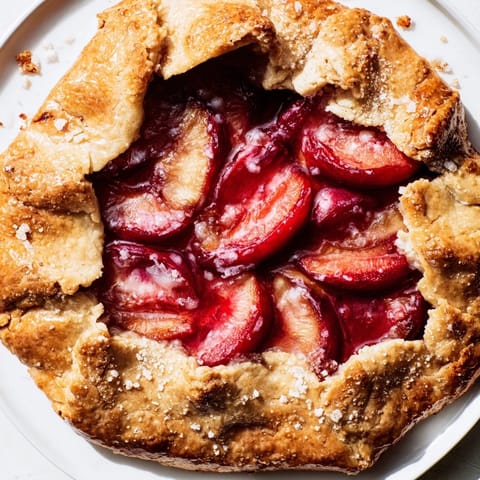 Juicy plums glistening within a rustic Honey and Plum Galette, baked to golden perfection.