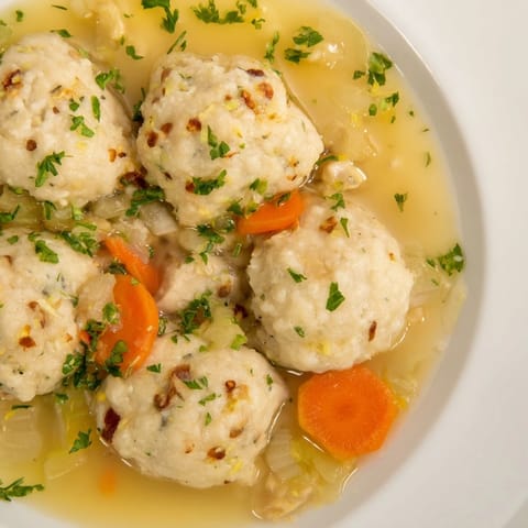 A comforting bowl of Nut-Warm Homestyle Chicken and Dumplings, with parsley garnish, ready to warm you up.