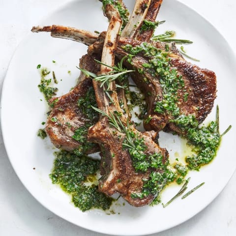 Close-up of succulent Rustic Mint Weeknight Pan-Seared Lamb Chops, beautifully tender with perfect sear marks, beside refreshing mint.