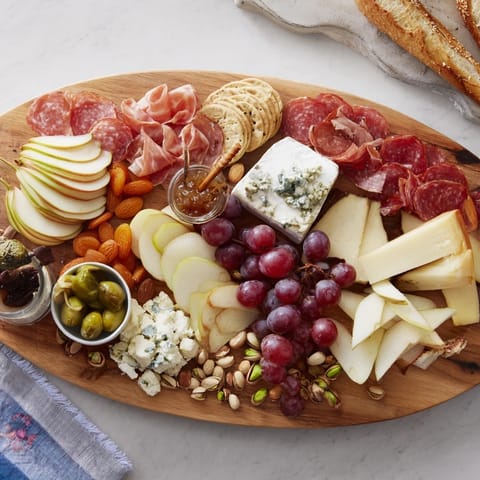 The Elegant Gilded Edge appetizer spread features creamy cheeses and charcuterie, surrounding the board's edge.