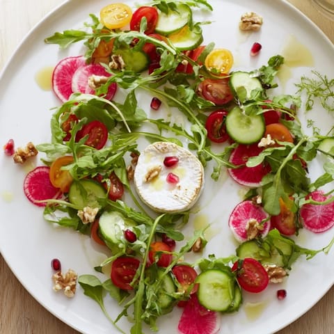 Vibrant Zenith Point salad featuring arranged ingredients cascading toward a soft cheese wheel.