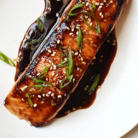 Savory ginger soy glazed salmon, pan-seared to perfection, offers a delightful sweet and umami experience.