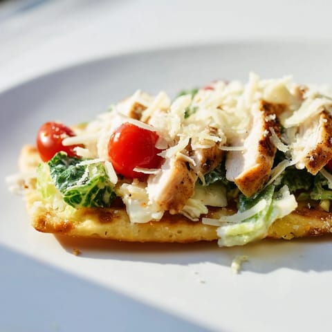 Sliced grilled chicken and fresh romaine sit atop a warm flatbread drizzled with rich Caesar dressing.  