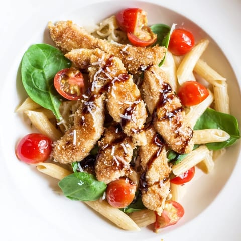 A close-up of balsamic glazed chicken pasta with melted Parmesan and fresh basil, served warm for an easy weeknight dinner.