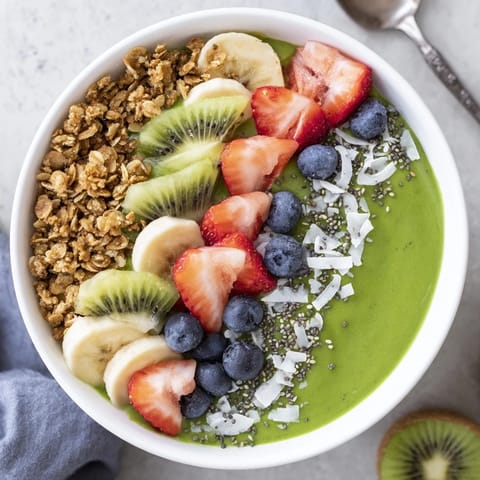 Close-up of a creamy spinach smoothie bowl with tropical fruit and chia seeds.