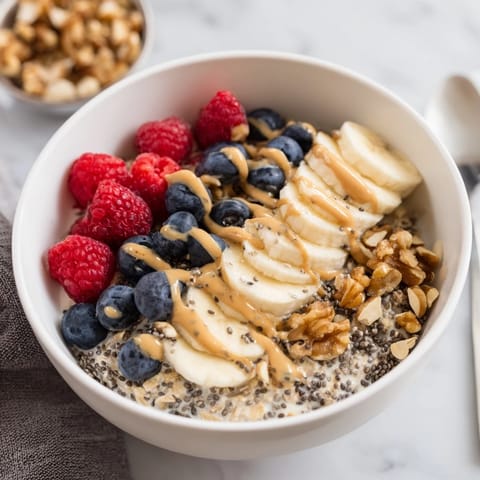 A creamy jar of Overnight Oats with chia seeds, layered with sliced banana and crunchy almonds.