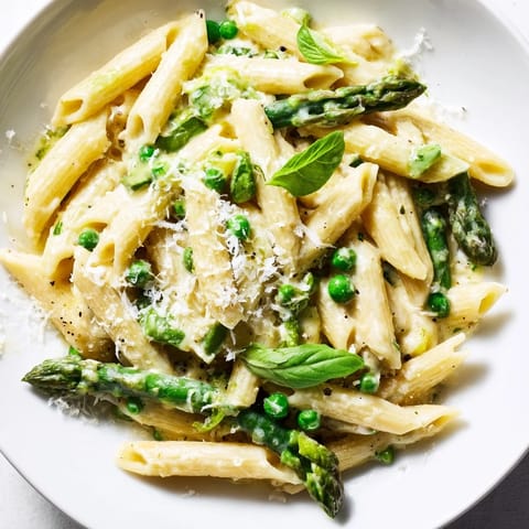 Serving suggestion for Garlic Parmesan Spring Vegetable Pasta, garnished with fresh basil, lemon zest, and extra grated Parmesan, ready to enjoy.