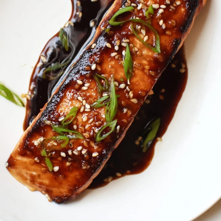 Savory ginger soy glazed salmon, pan-seared to perfection, offers a delightful sweet and umami experience.