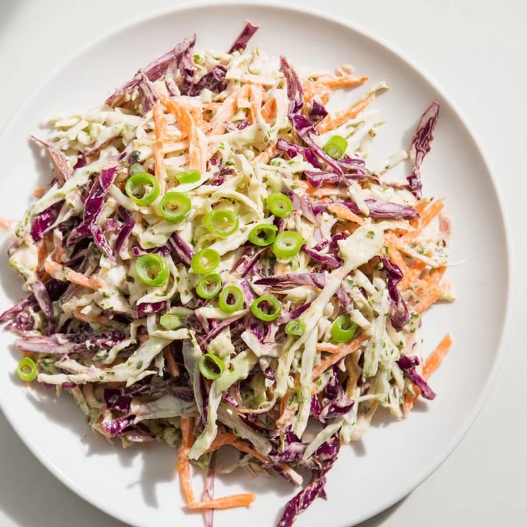 This quick coleslaw salad, with a creamy white dressing, offers a refreshing side dish for sandwiches.