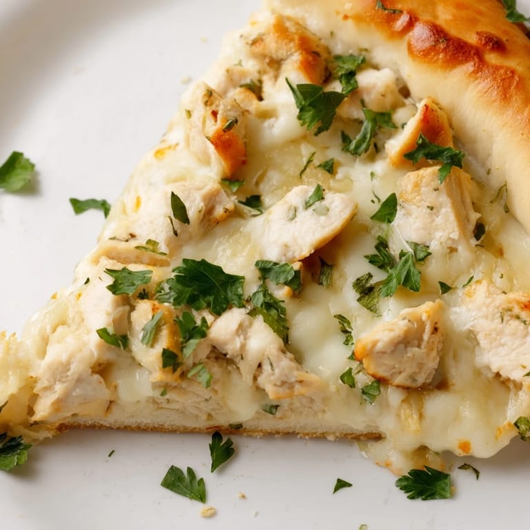 Rustic Chicken Alfredo Pizza on a baking sheet, featuring a crispy crust and fresh parsley garnish.