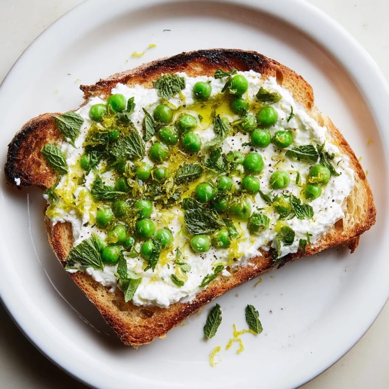 Vibrant Pea & Mint Ricotta Toast spread generously, finished with a drizzle of olive oil and black pepper.
