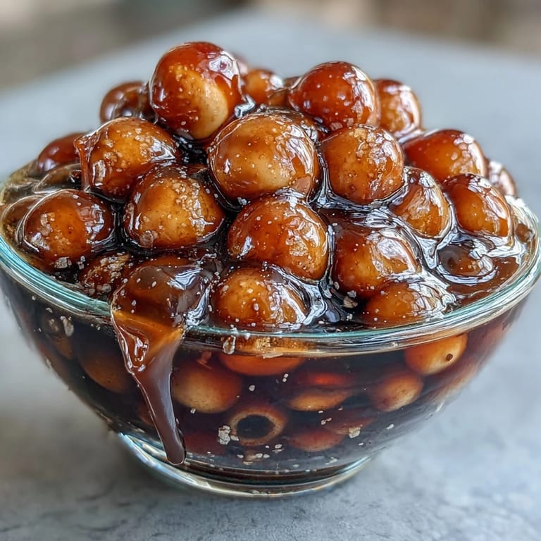 Refreshing black tea and milk combine with glossy brown sugar boba pearls, perfect for bubble tea lovers craving authentic flavor.