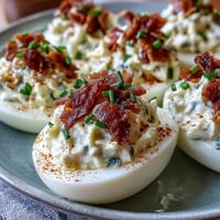 Crispy bacon and creamy ranch deviled eggs, garnished with chives and paprika for a savory Easter appetizer.